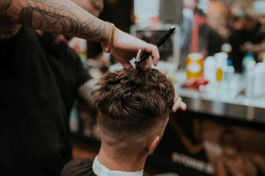 Corte de cabelo sendo finalizado na cadeira.